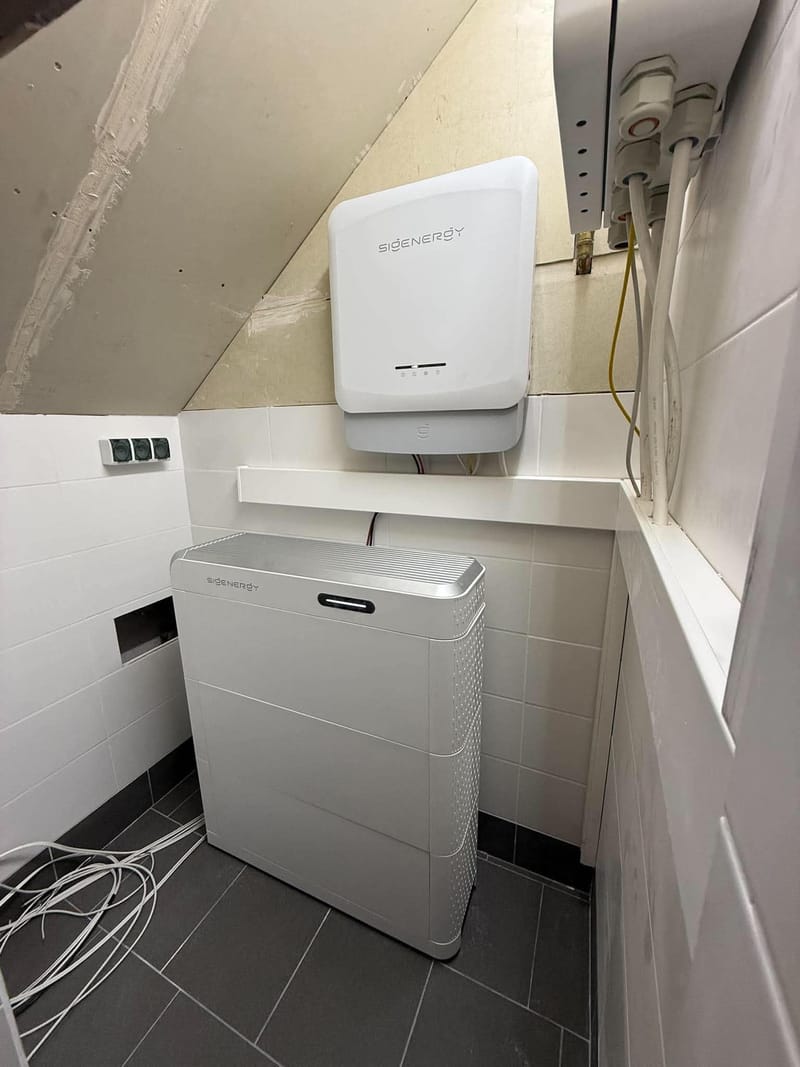 Falownik hybrydowy Sigenergy na ścianie i modułowy magazyn energii SigenStor 27 kWh w pomieszczeniu ze skosem